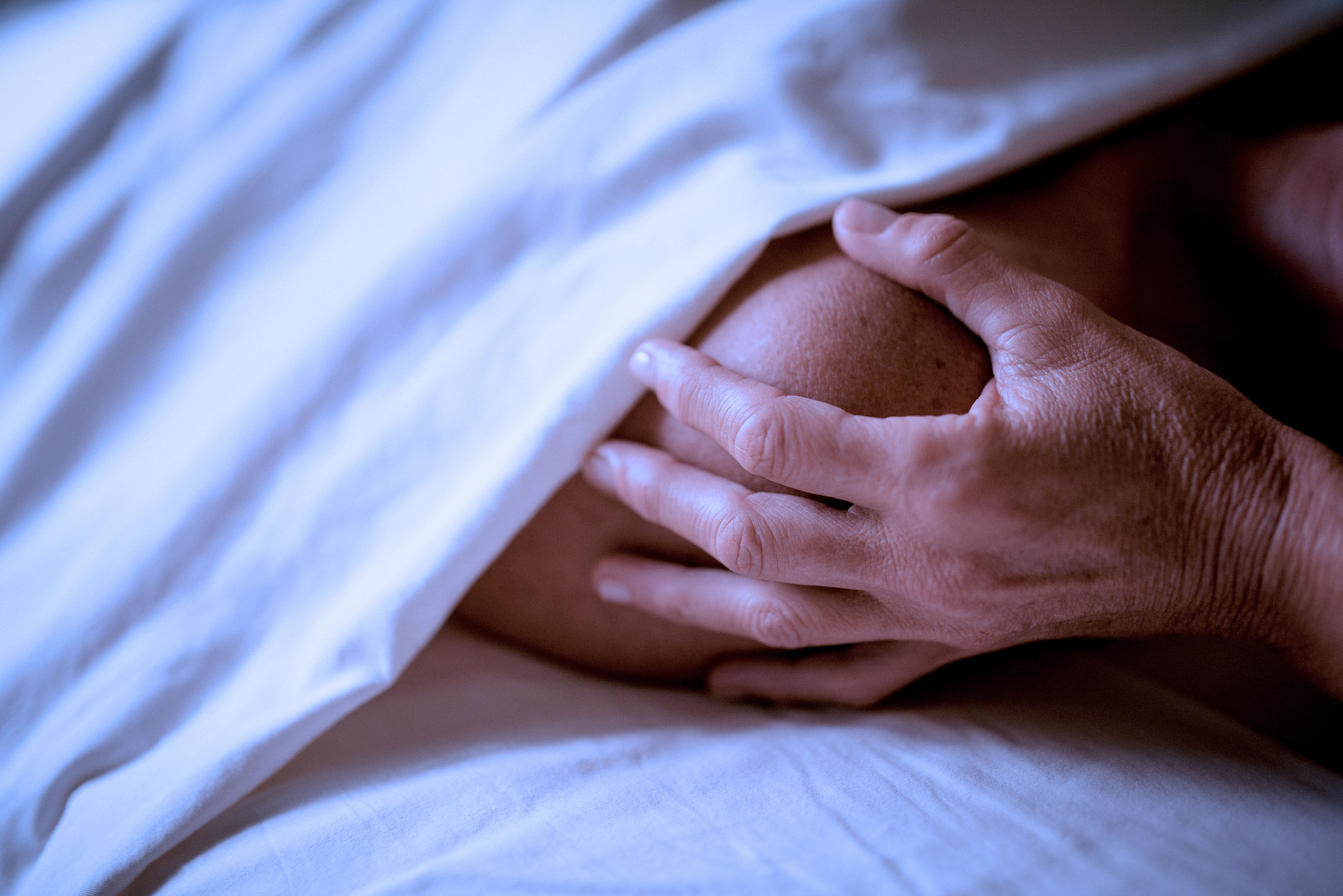Gentle craniosacral therapy with a hand resting on a client's shoulder