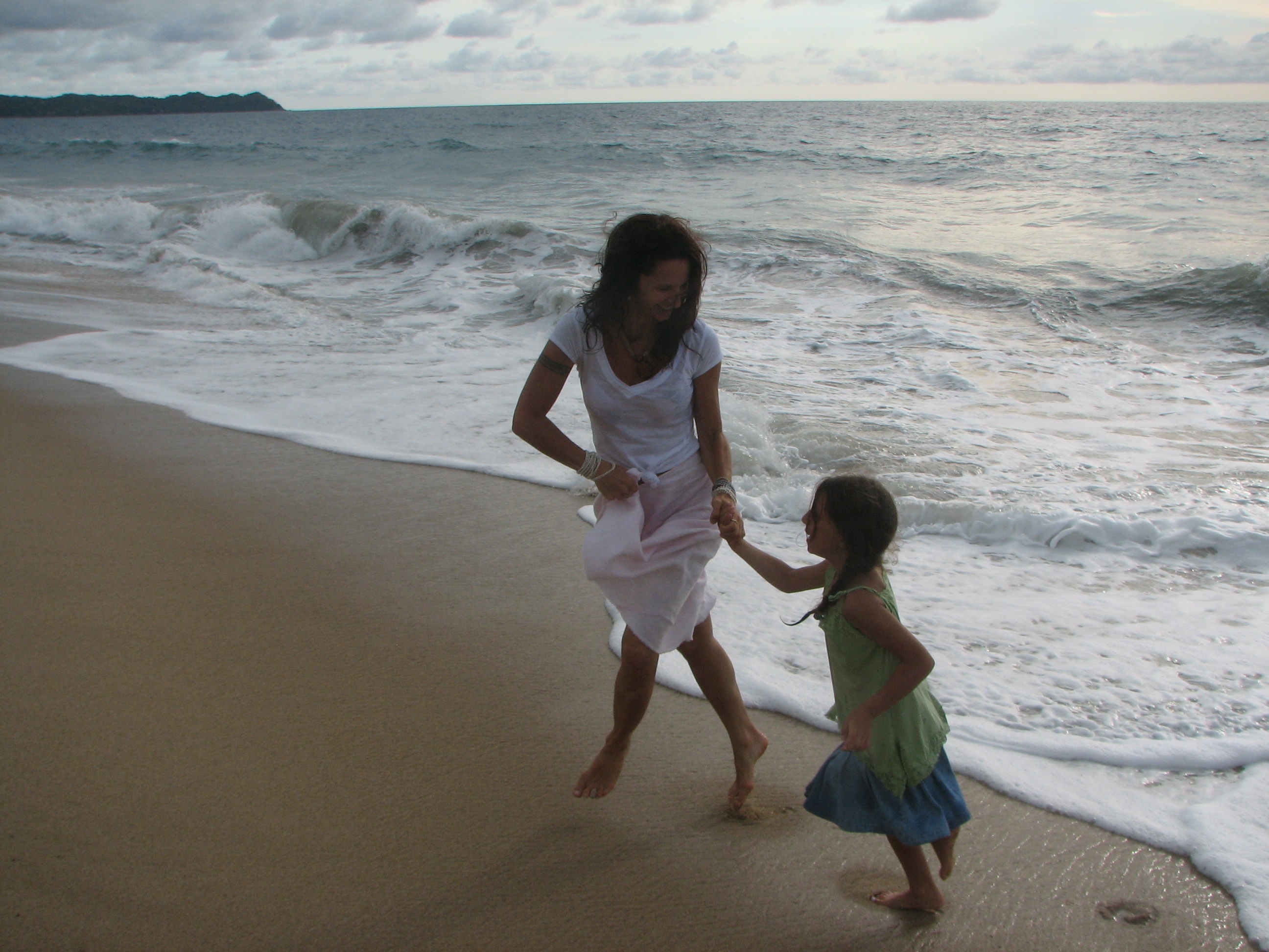 Isabella and a child walking along the shore